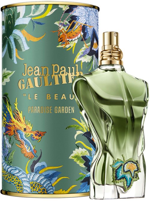 Ein Parfümflasche in Frauenform mit grünem Flüssigkeit vor einer dekorativen Schachtel mit Drachen und Pflanzen.