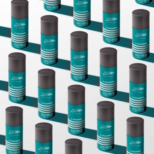 Mehrere Deodorantstifte mit schwarzen Kappen und blauen Etiketten sind in einem Muster angeordnet und werfen Schatten.