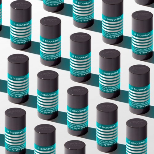 Mehrere blaue und schwarze Deosticks in einem Muster auf einer reflektierenden Oberfläche.
