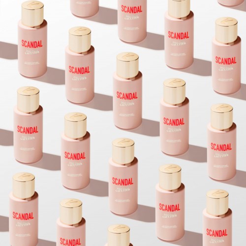 Meerdere roze flessen met 'SCANDAL' erop, gerangschikt in een patroon met schaduw op een lichte achtergrond.