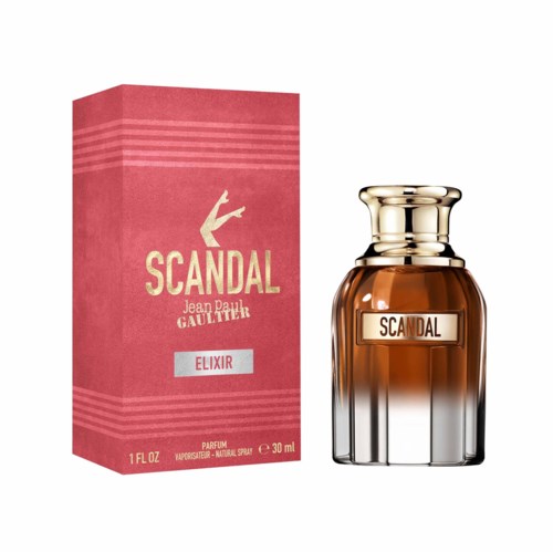 Een parfumfles met het label 'Scandal Elixir' naast de roze doos. De fles is bruin met een glanzende gouden dop.