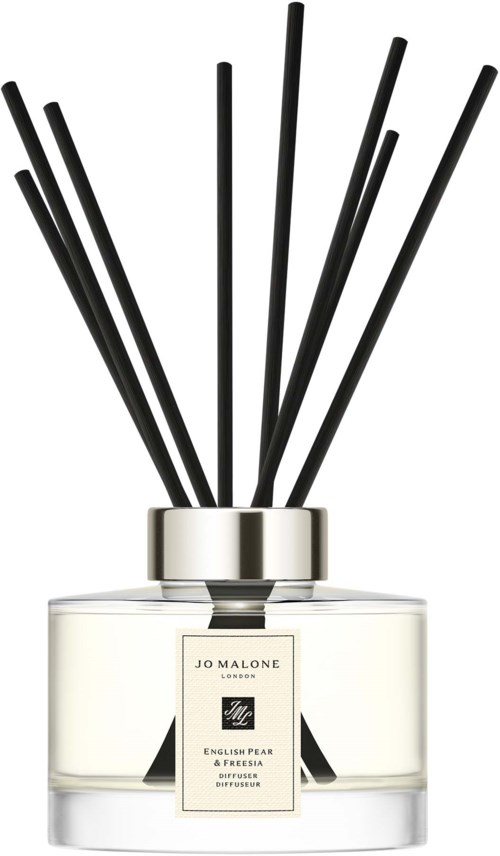 Valkoinen hajuvesipurkki, jossa on mustia tikkuja takana, merkki 'Jo Malone London.'