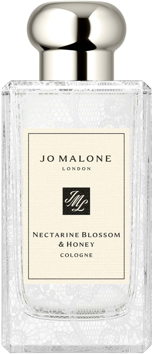 En tydlig parfymflaska av glas med en silverkapsel och en etikett för Jo Malone Nectarine Blossom och Honey cologne.