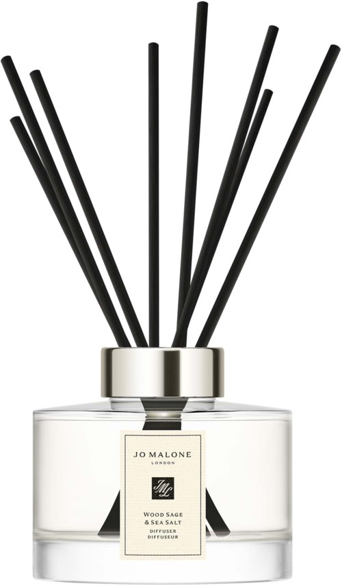 Läpinäkyvä lasipurkki, jossa on mustia vartta, nimeltään 'Jo Malone Wood Sage & Sea Salt' diffuuseri.