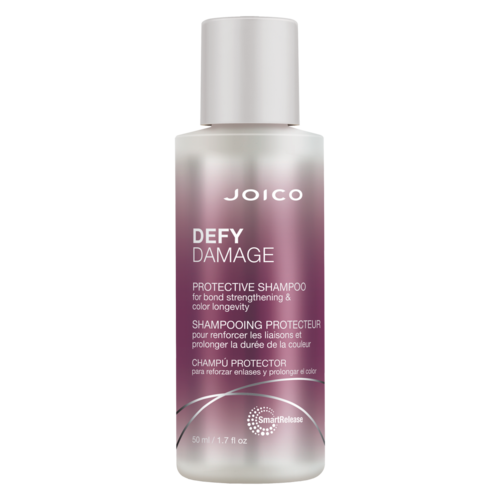 Eine Flasche Joico Defy Damage Schutzshampoo für starkes, lang anhaltendes Haar. Weißer Deckel, lila Farbverlauf-Etikett, Markennamen sichtbar.