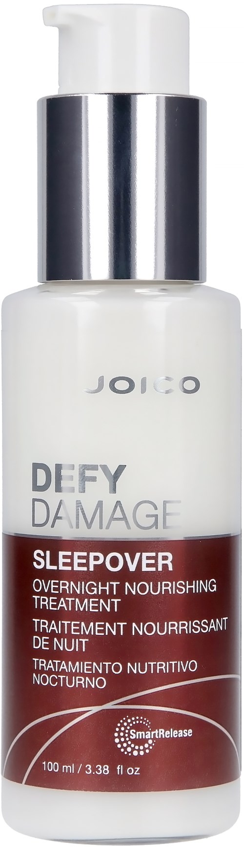 Een witte fles met een zilveren dop, gelabeld 'Joico Defy Damage Sleepover' voor nachtbehandeling.