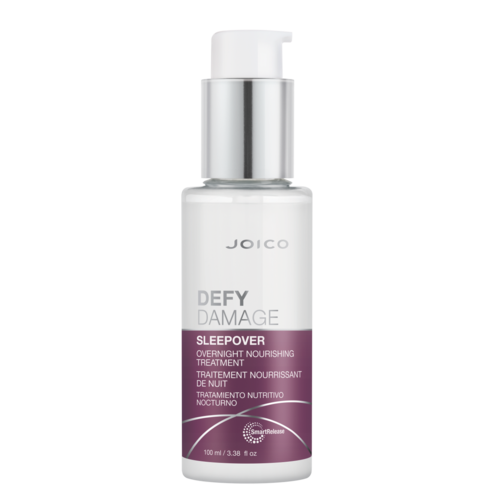Een witte fles met pomp met het label Joico Defy Damage Sleepover nachtbehandeling.