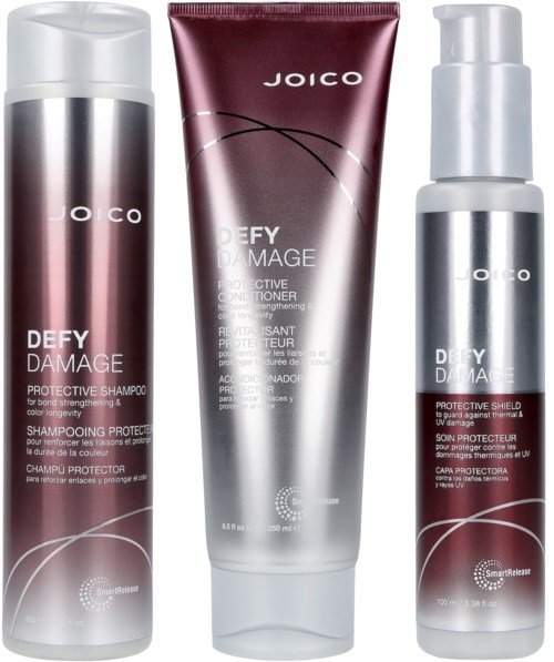 Drei Haarpflegeprodukte von Joico mit der Aufschrift 'Defy Damage', darunter Shampoo, Conditioner und Schutzspray.