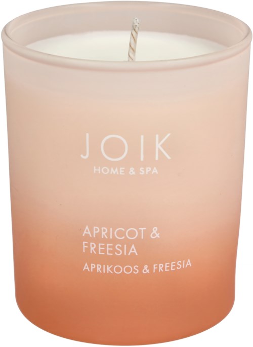 A pink candle in a glass container labeled 'Joik Home & Spa' with apricot and freesia scent.