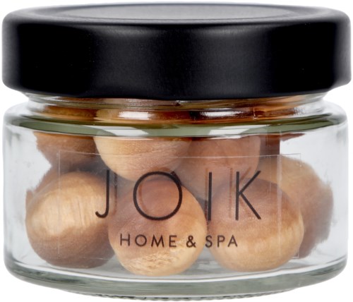 A jar with round nuts or seeds and a black lid, labeled "JOK Home & Spa."