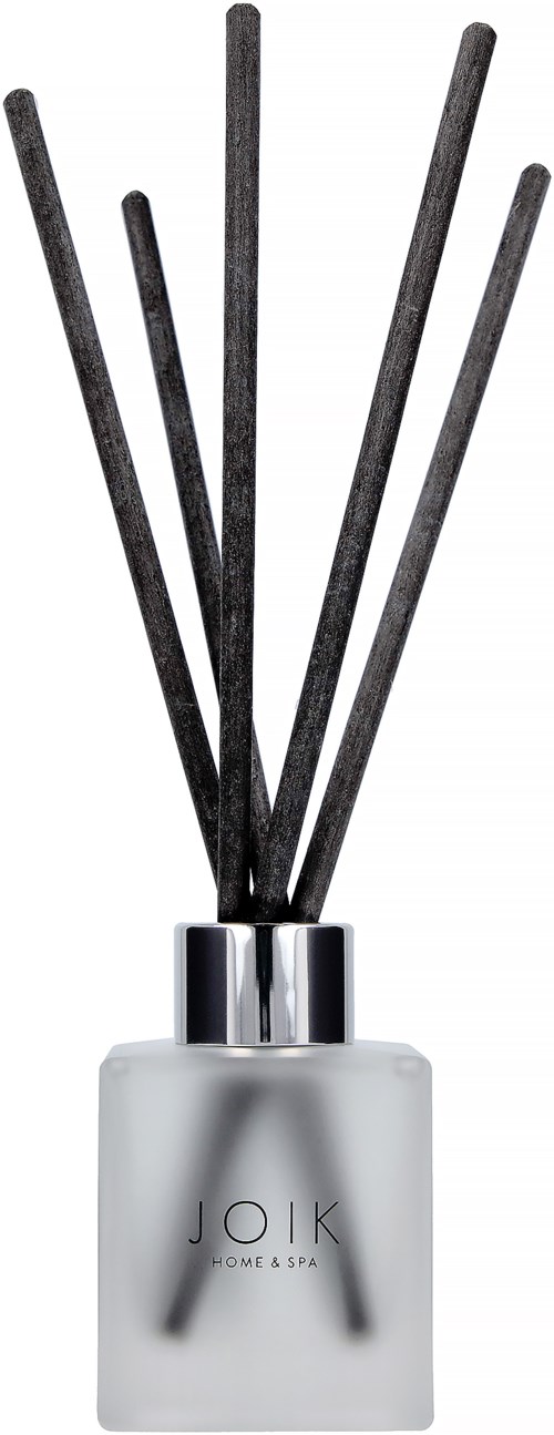 A white bottle with black sticks, labeled 'JOIK HOME & SPA', likely a reed diffuser for scent.