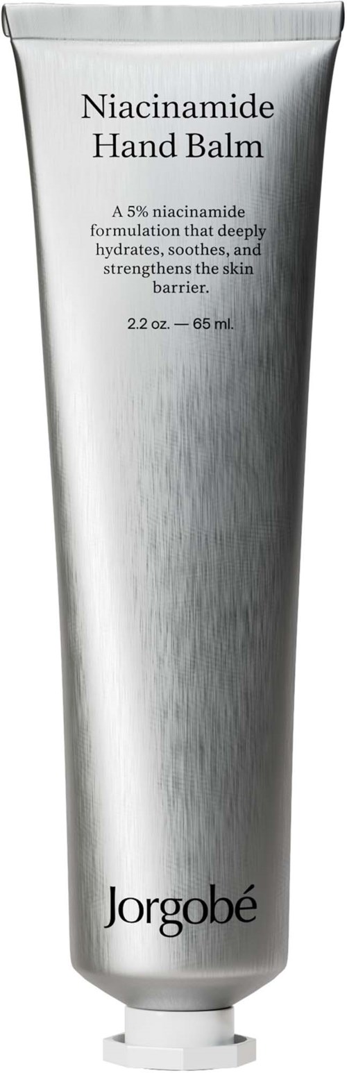 Een zilverkleurige tube met label Niacinamide Hand Balm door Jorgobé. Het maakt de huid zacht en sterk.