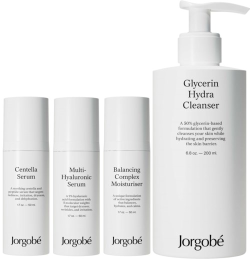 Een huidverzorgingsset met vier flessen, inclusief cleanser, serums en vochtinbrengende crème, in witte verpakking.