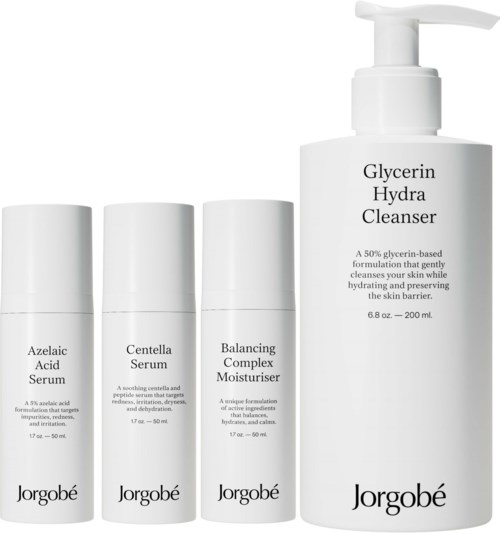 Een huidverzorgingsset met drie kleine flessen en één grote pompflacon, gelabeld voor serums, vochtinbrenger en reiniger.