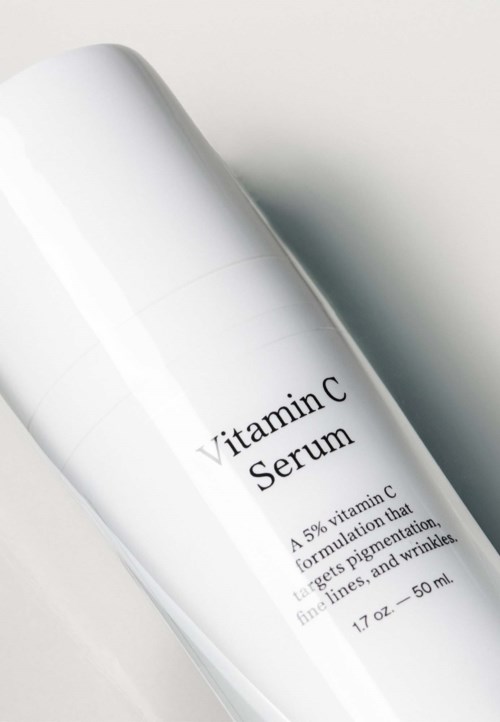 En hvit flaske merket 'Vitamin C Serum' med informasjon om dens vitamin C-formulering, 50 ml.