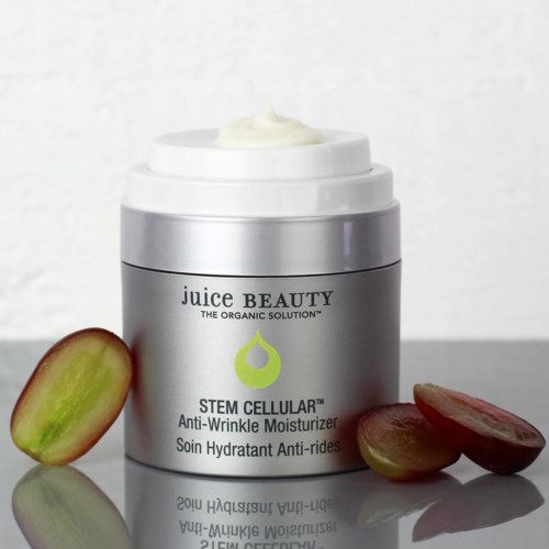 A silver jar of skincare cream with grapes beside it, labeled 'Stem Cellular Anti-Wrinkle Moisturizer' by Juice Beauty.