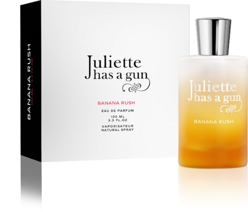A perfume bottle with a white box, both labeled Juliette Has a Gun Banana Rush, orange and white spray bottle.