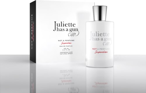 Een wit parfumflesje en doos met zwarte, roze en zilveren tekst, voorzien van een strak modern ontwerp.