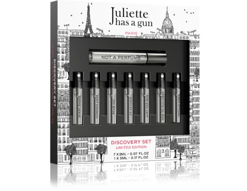 Een parfumontdekset met zeven kleine flesjes, allemaal gelabeld 'NOT A PERFUME,' in decoratieve verpakking met Parijs-figuren.