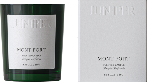 A green glass candle jar with a white label and a white box, both labeled "Mont Fort" and "Juniper" scent.