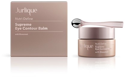 Ein Glas Jurlique-Augencreme und seine Verpackung, beide mit 'Supreme Eye Contour Balm' beschriftet, mit einem kleinen Löffel oben.