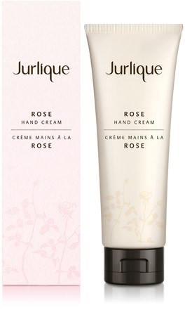A tube of Jurlique Rose Hand Cream next to the pink box with similar branding and floral design.