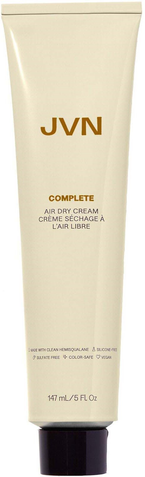 Eine Tube JVN Complete Air Dry Cream mit goldener und schwarzer Schrift auf beige Hintergrund.