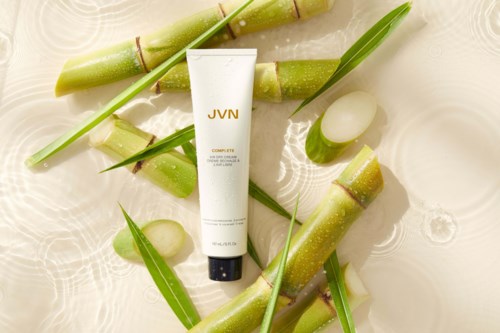 Eine Tube mit JVN-Label, umgeben von Bambussprossen, grünen Blättern und Wasser, für eine frische, natürliche Szene.