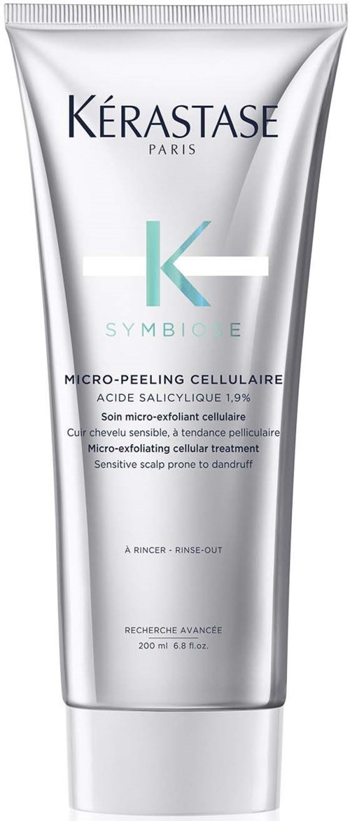 Een zilveren tube met Kérastase Symbiose micro-exfoliërende cellulaire behandeling, met tekst over het product.