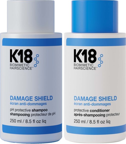 Two white bottles with blue caps, labeled for damage protection: one shampoo and one conditioner.