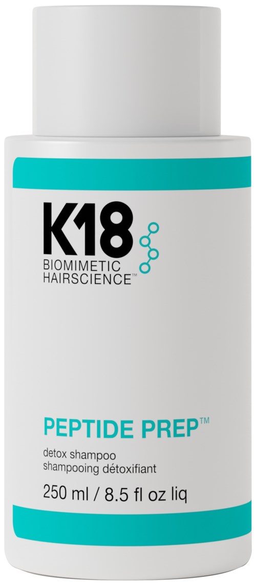 A white bottle of K18 peptide prep shampoo with blue accents, labeled as a detox shampoo for hair care.