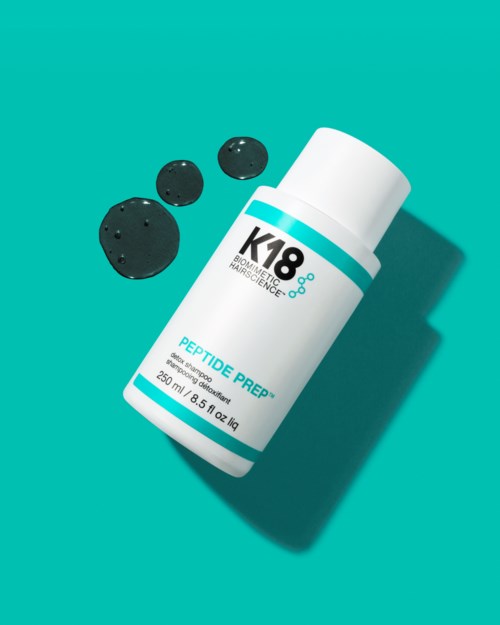 A bottle labeled 'Peptide Prep' with black tablets beside it on a teal background.
