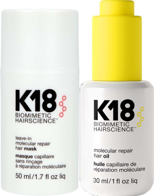 Two white bottles with black and red or yellow text, labeled for hair repair and oil, are shown side by side.