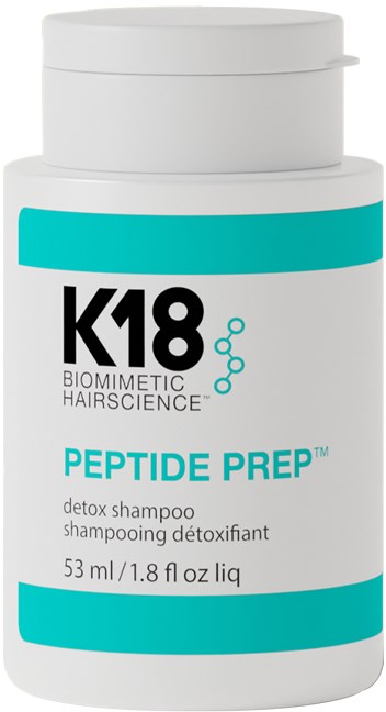 A white bottle of K18 Peptide Prep detox shampoo with blue and black text, and a small molecular graphic.