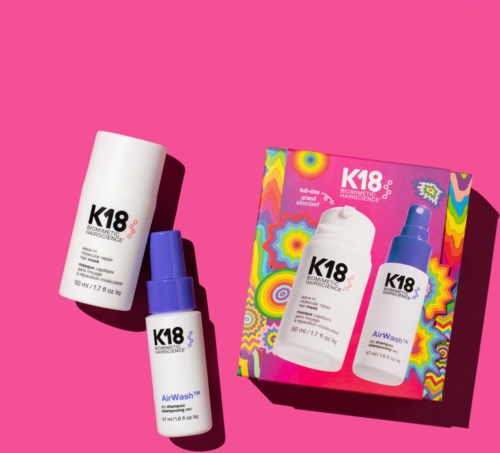 K18 shampoo and leave-in treatment bottles with a colorful box against a pink background.
