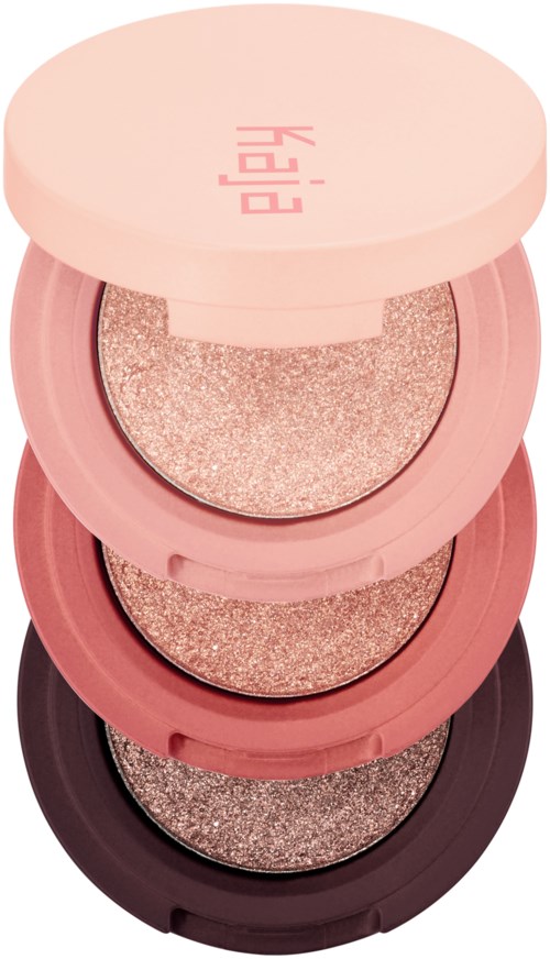 Ein Stapel von vier runden, rosa und schwarzen Lidschattenpaletten mit glitzernden Farbtönen.