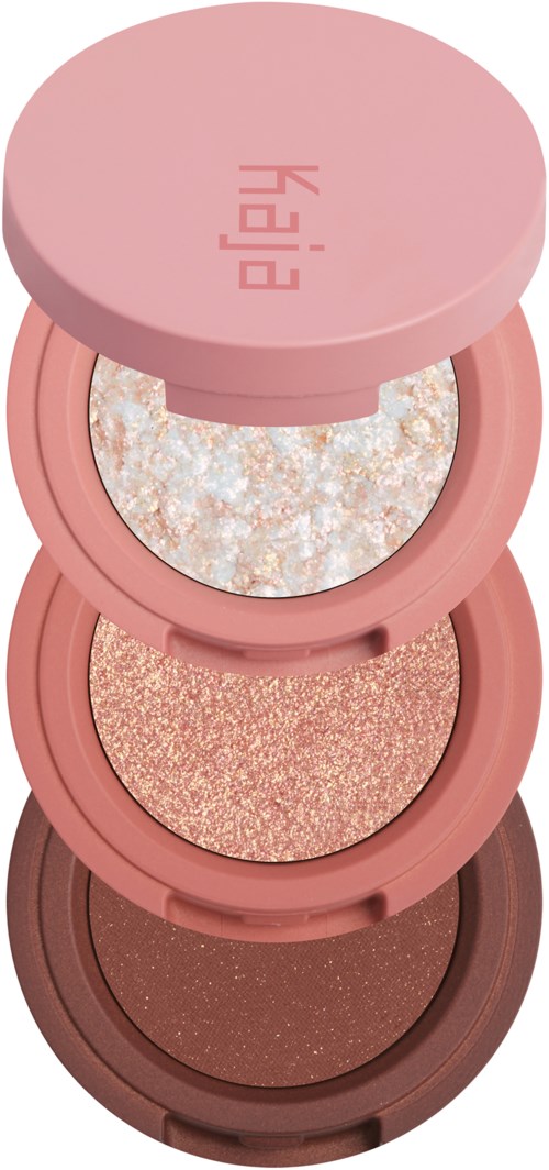 Een stack van vier ronde make-updoosjes in roze en bruin, elk met verschillende glanzende, glinsterende oogschaduw.