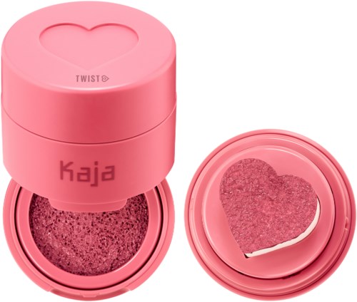 Een roze hartvormige spons in een ronde roze container met dekseltje. De container heeft het woord 'KAJA' erop.