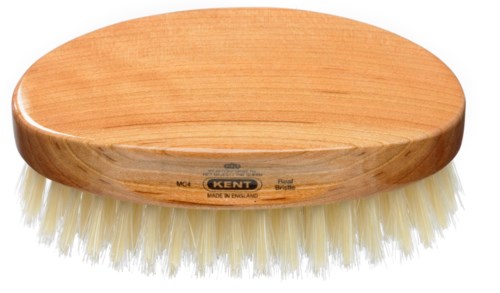 Eine Holzpolierbürste mit weißen Borsten, ovale Form, Etikett auf der Seite, verwendet für Reinigung oder Polieren.