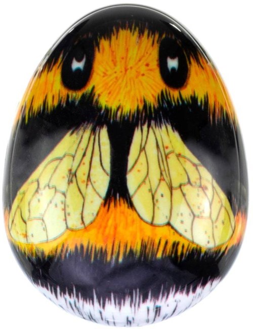 A painted egg with a butterfly's face and wings, combining bright orange, black, yellow, and white colors.