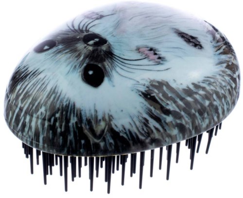 A grooming brush with an image of a seal's face on it, long black bristles, and a round shape.