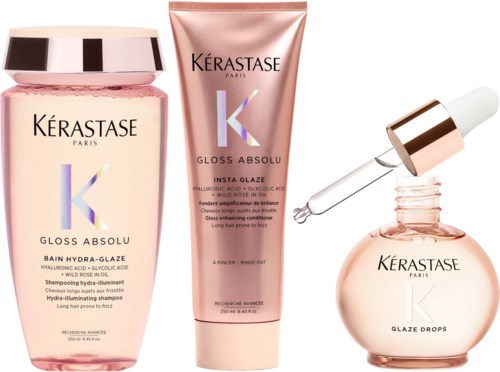 Drie Kérastase haarproducten: shampoo, haarmasker en serum, in roze en roségoud verpakking.