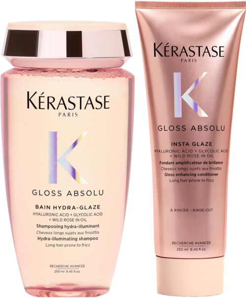 Twee haarverzorgingsproducten, een fles en een tube, beide roze met zwarte en zilveren tekst, van Kérastase.
