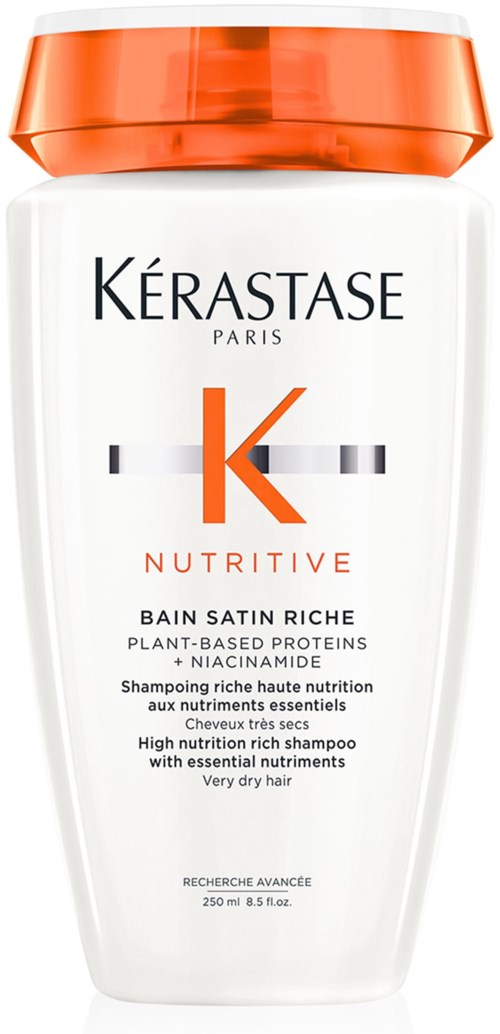 Een witte shampoo fles met oranje dop, gelabeld Kérastase Nutritive voor zeer droog haar.