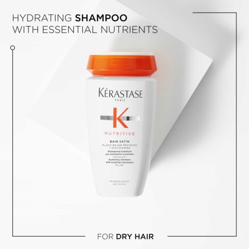 Een witte shampoo fles met oranje deksel, gemerkt voor droog haar, bevat voedingsstoffen voor hydratatie.