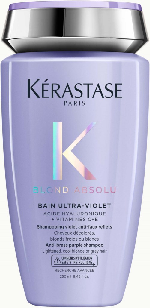 Eine lila Flasche mit silbernem und schwarzem Deckel, gekennzeichnet Kérastase Blond Absolu Shampoo für blondes oder graues Haar.