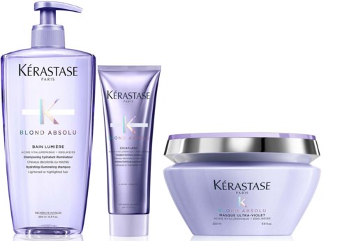 Three hair care products with purple packaging from Kérastase, including a pump bottle, a tube, and a jar.