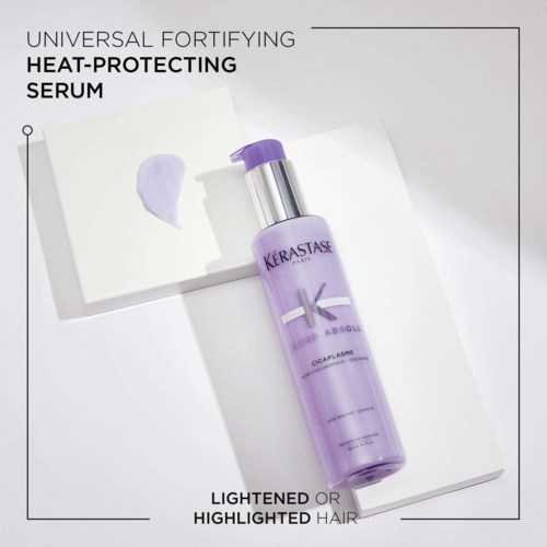 A purple bottle of Kerastase hair serum with a pump, placed on a white surface with some paper and cream.