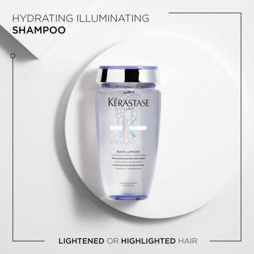 Eine klare Flasche Kérastase Hydrating Illuminating Shampoo vor weißem Hintergrund, betont die Helligkeit oder Glanz des Haars.