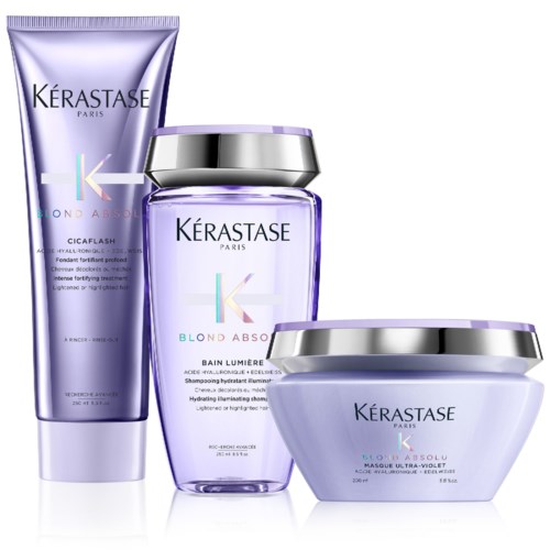 Tre violett hårprodukter från Kérastase, inklusive en duschgel, en behandling och en mask, i glänsande burkar.